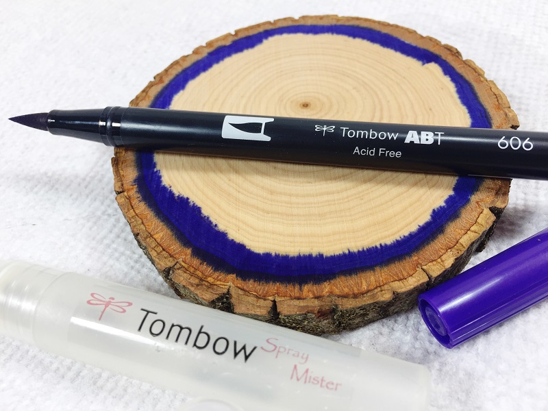 Learn how to make Ultra Violet Faux Agates on a wood slice with Tombow Dual Brush Pens, the Tombow Mister and Tombow MONO Aqua Liquid Glue