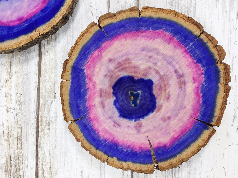 Learn how to make Ultra Violet Faux Agates on a wood slice with Tombow Dual Brush Pens, the Tombow Mister and Tombow MONO Aqua Liquid Glue