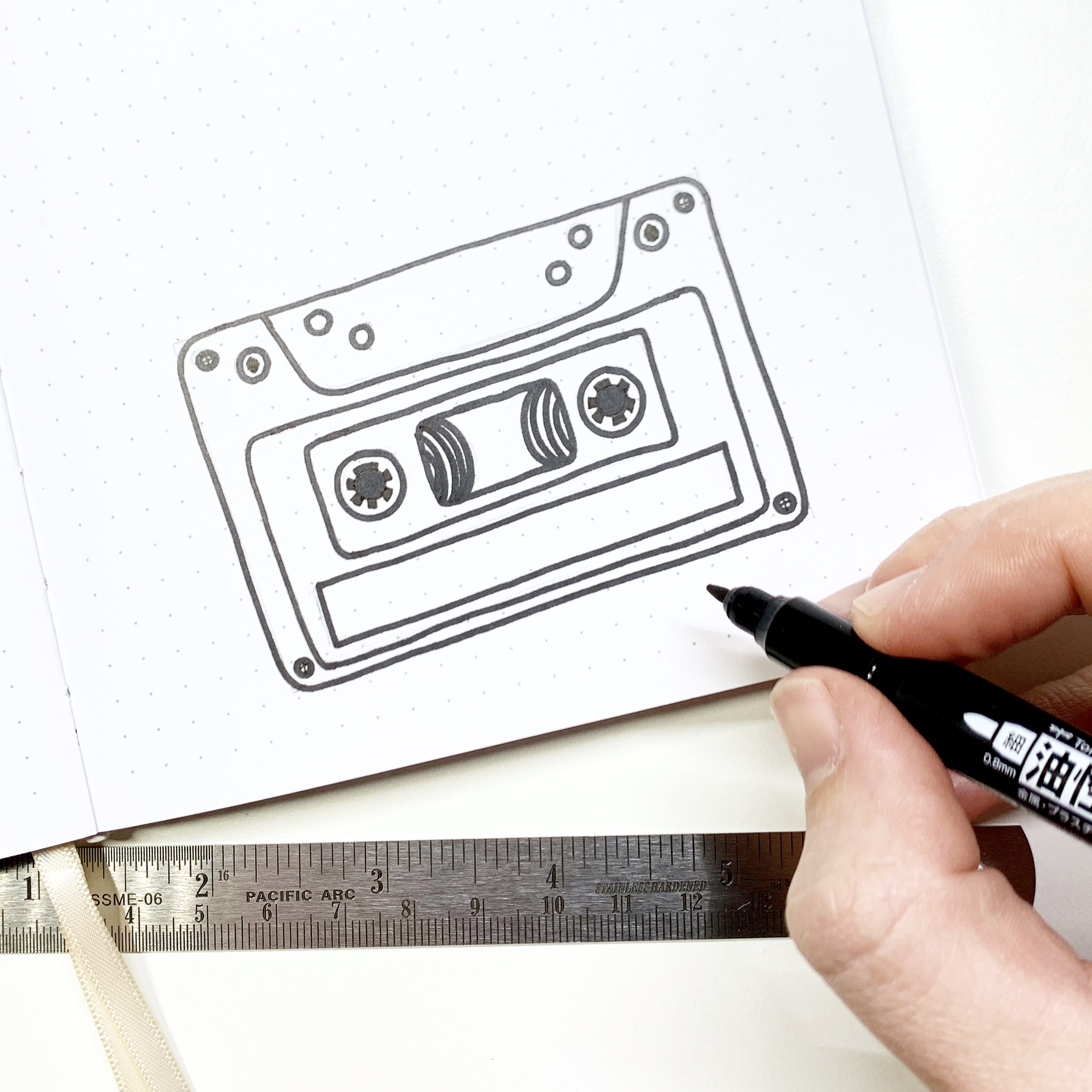 Learn how to create a cassette tape habit tracker in your dot grid notebook with Adrienne from @studio80design!