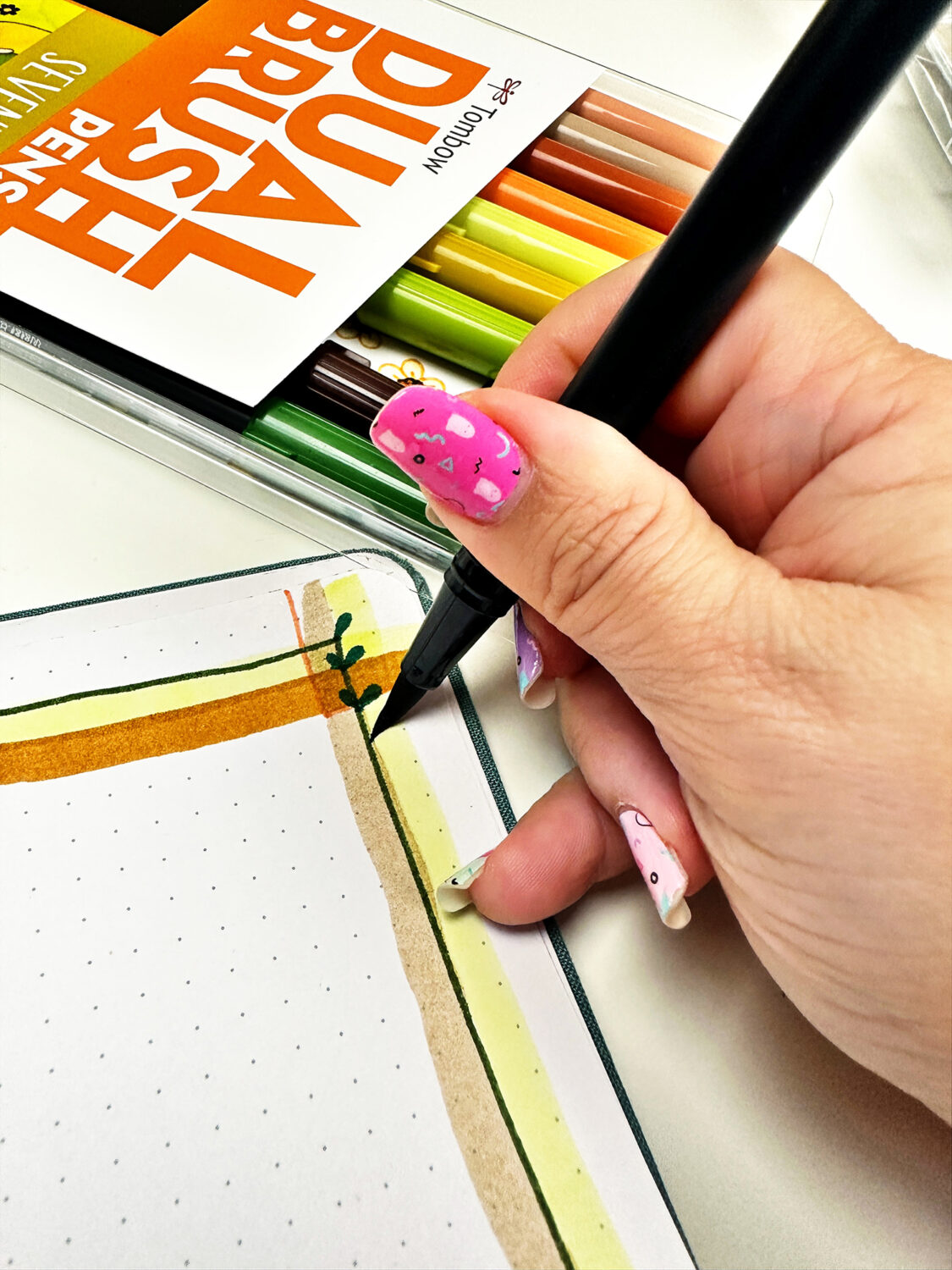 Draw a line and add doodle dabs leaves to create a vine border. To create a doodle dab, simply angle the Tombow Dual Brush Pens and press the tip of the brush pen on the paper. #tombow #journaling