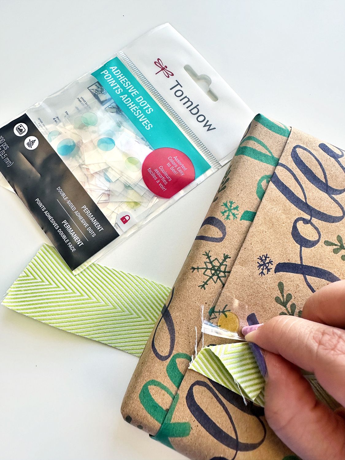 Use Tombow Adhesive Dots to glue ribbon on gift wrapping. #tombow #giftwrapping