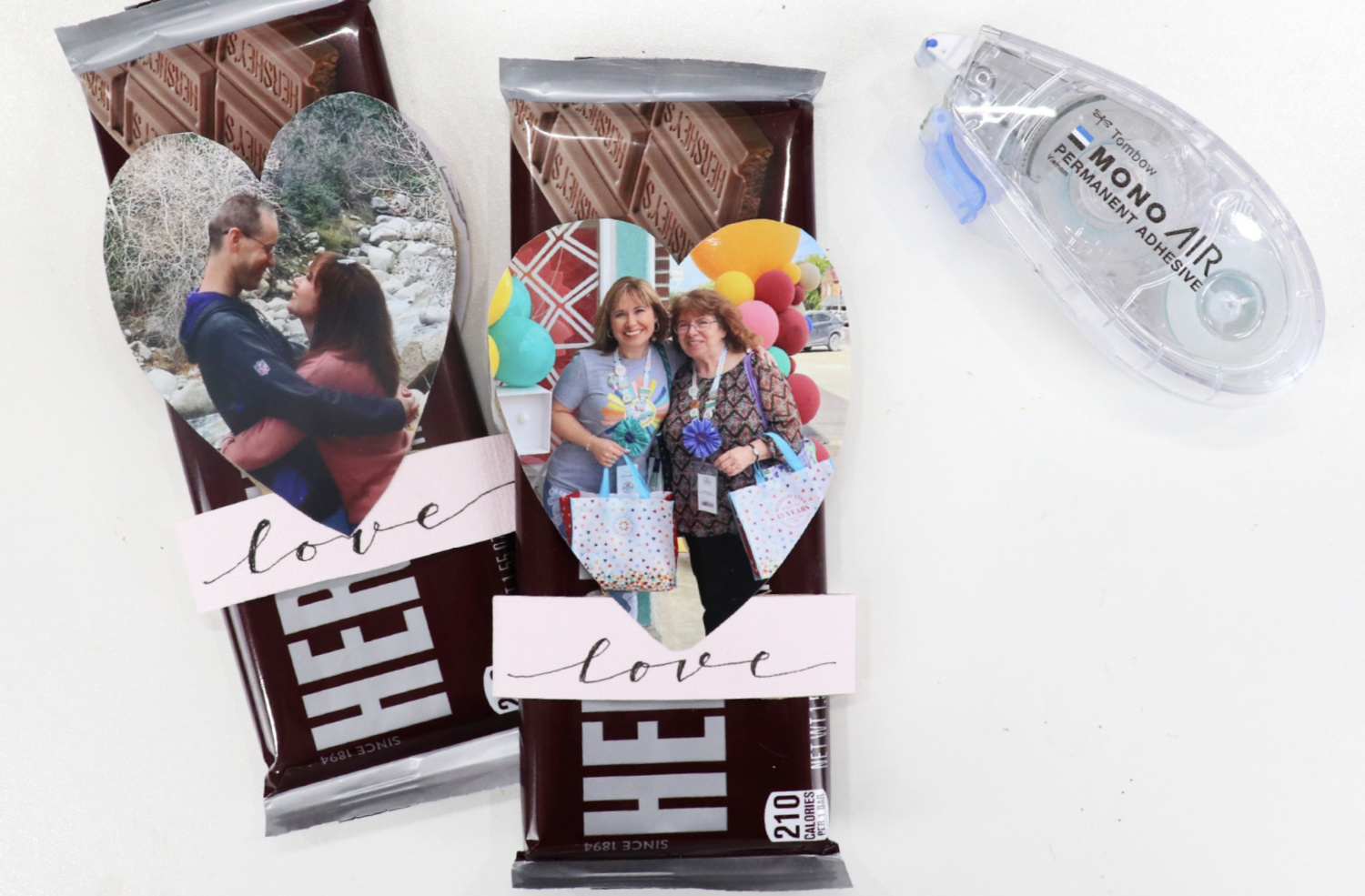 Image contains two chocolate bars, each with one of the paper roll Valentines slid onto it. The photo sides of the projects are visible. A MONO Air Touch adhesive runner sits beside them on a white background.