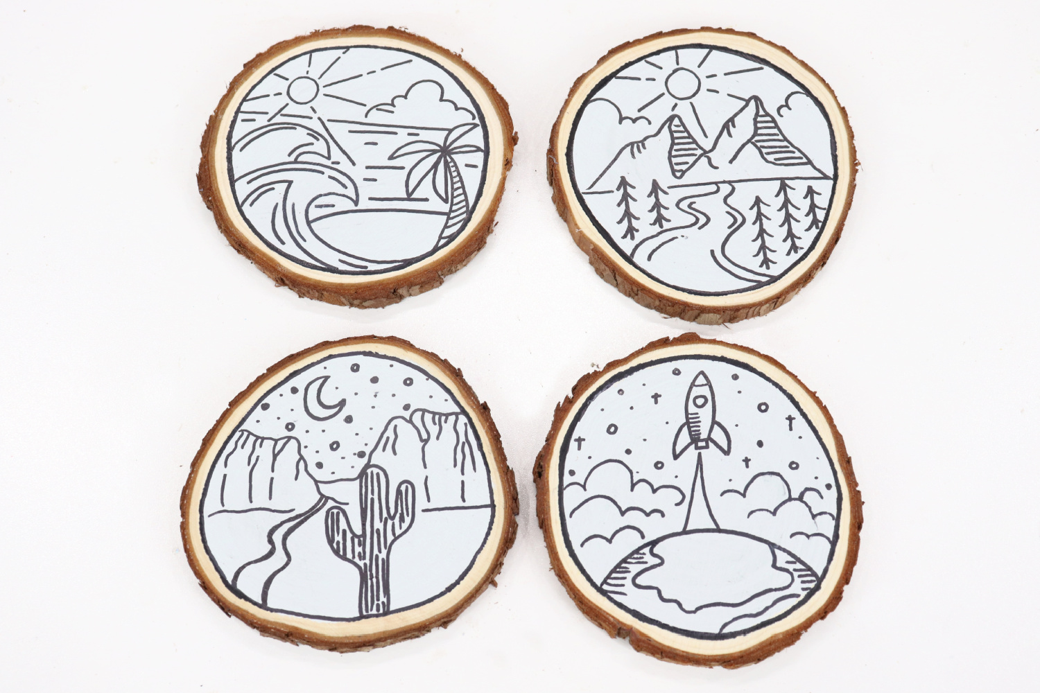 Image contains four monoline travel coasters: one is beach themed, one mountain themed, one desert themed, and one space themed, on a white background.