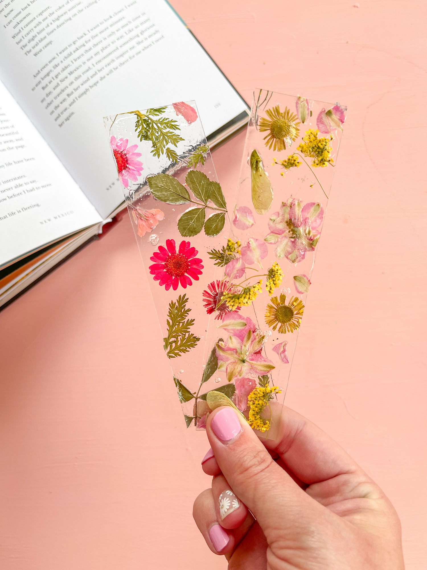 Hand holding 2 aesthetic flower bookmarks