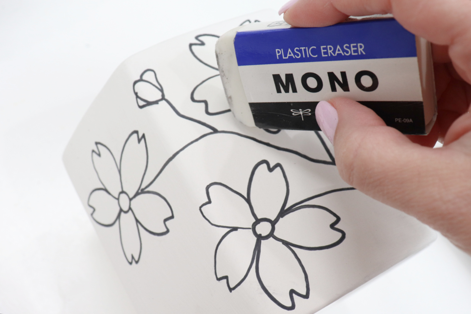 Image contains Amy’s hand holding a MONO Eraser, removing pencil lines from the white planter.