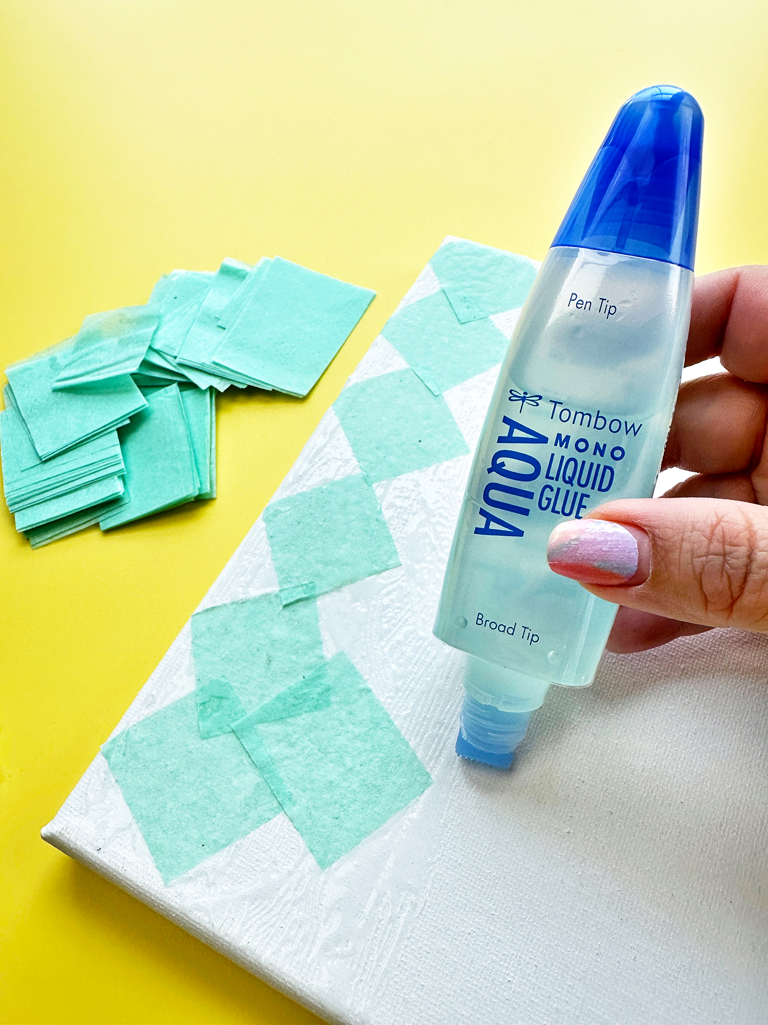 To cover the background use tissue paper. I used only one sheet to cut a lot of squares and rectangles. Use the broad tip of the Tombow MONO Aqua Liquid Glue to apply the glue on the background. I like the broad tip because then I don't have to use and clean a brush! #tombow
