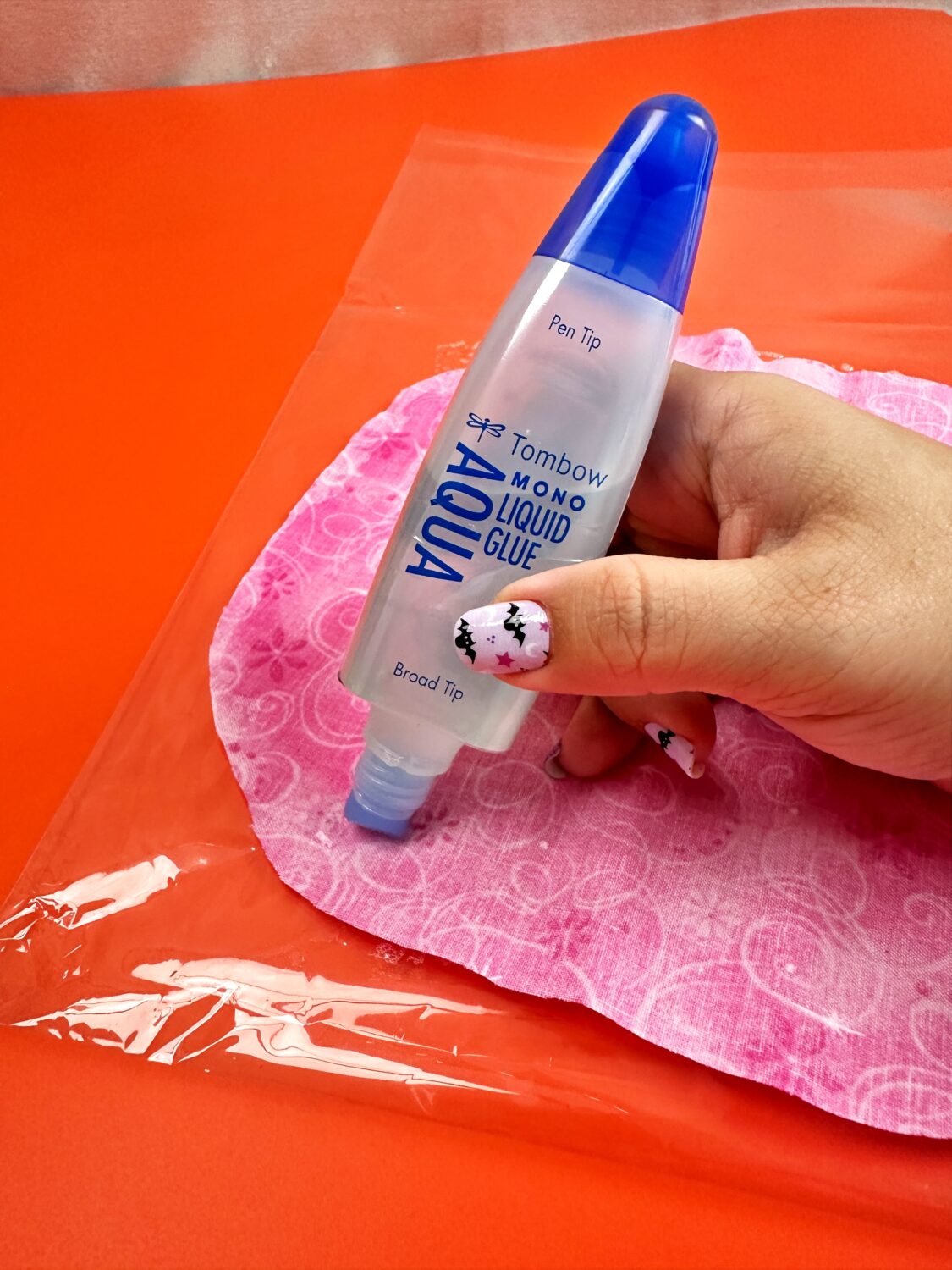 Use the broad tip of the Tombow MONO Aqua Liquid Glue to spread glue on the back of the fabric circle. Make sure that is completely saturated.  #tombow #halloweendiy