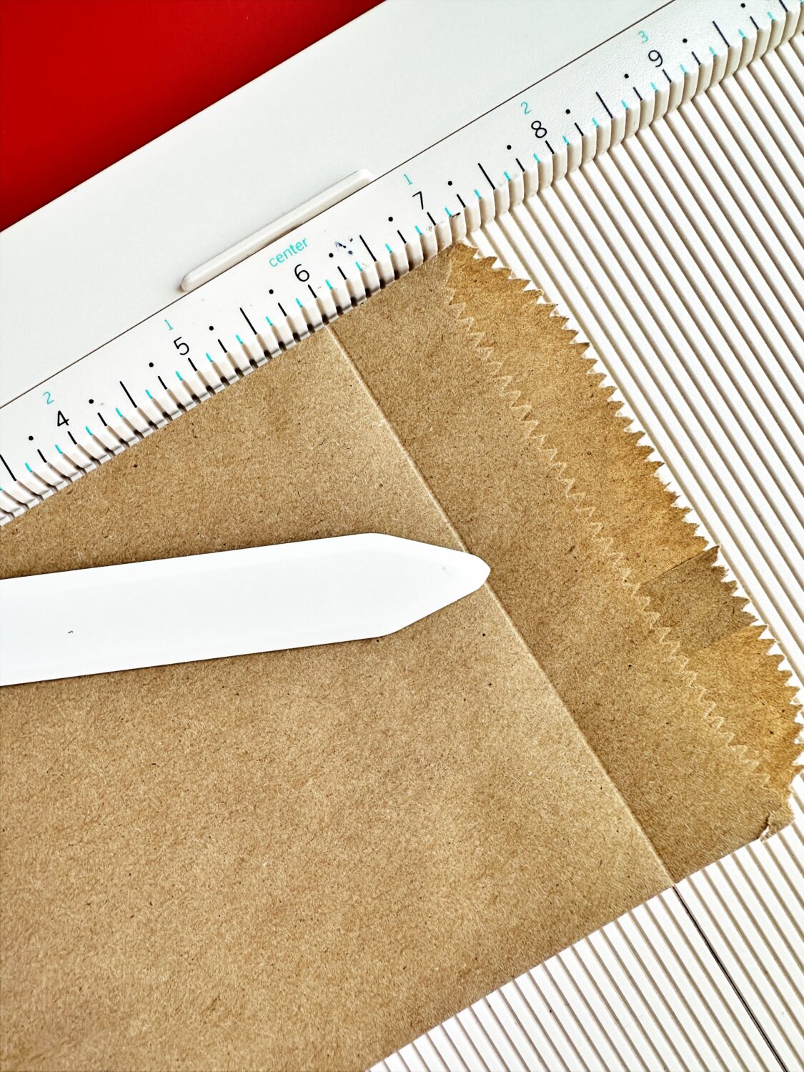 I used a scoreboard and a bone folder to create the flap on the bag. The scoreboard helped me make the fold in the same spot in every bag. You can just fold the bag and crease it.  #tombow #adventcalendar