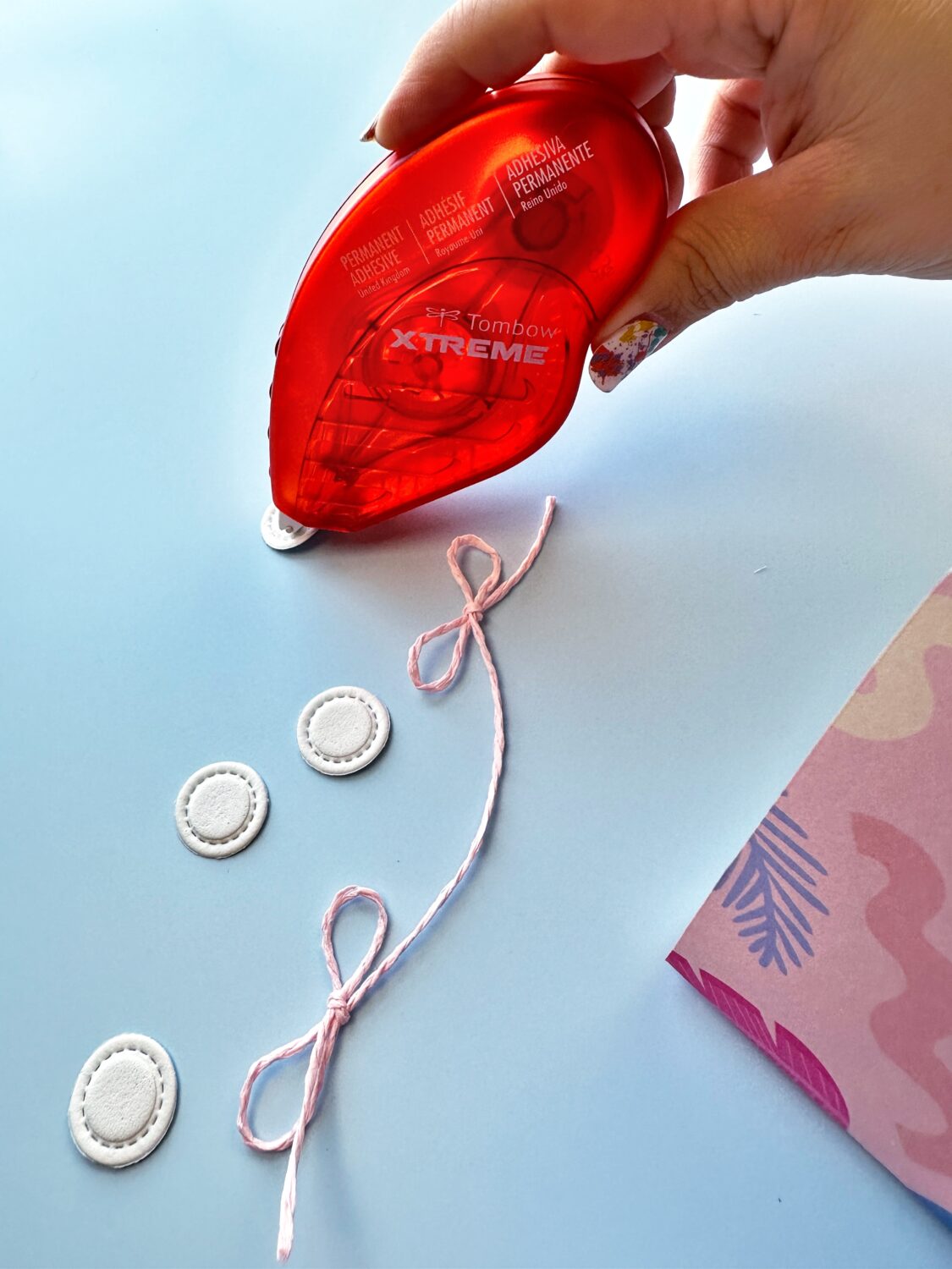 I used twine to create the string for the bracelet. You can just to a know instead of a bow. Add the circle "beads" to the string using the Tombow Xtreme Adhesive on the back of the circles. #tombow #papercrafts