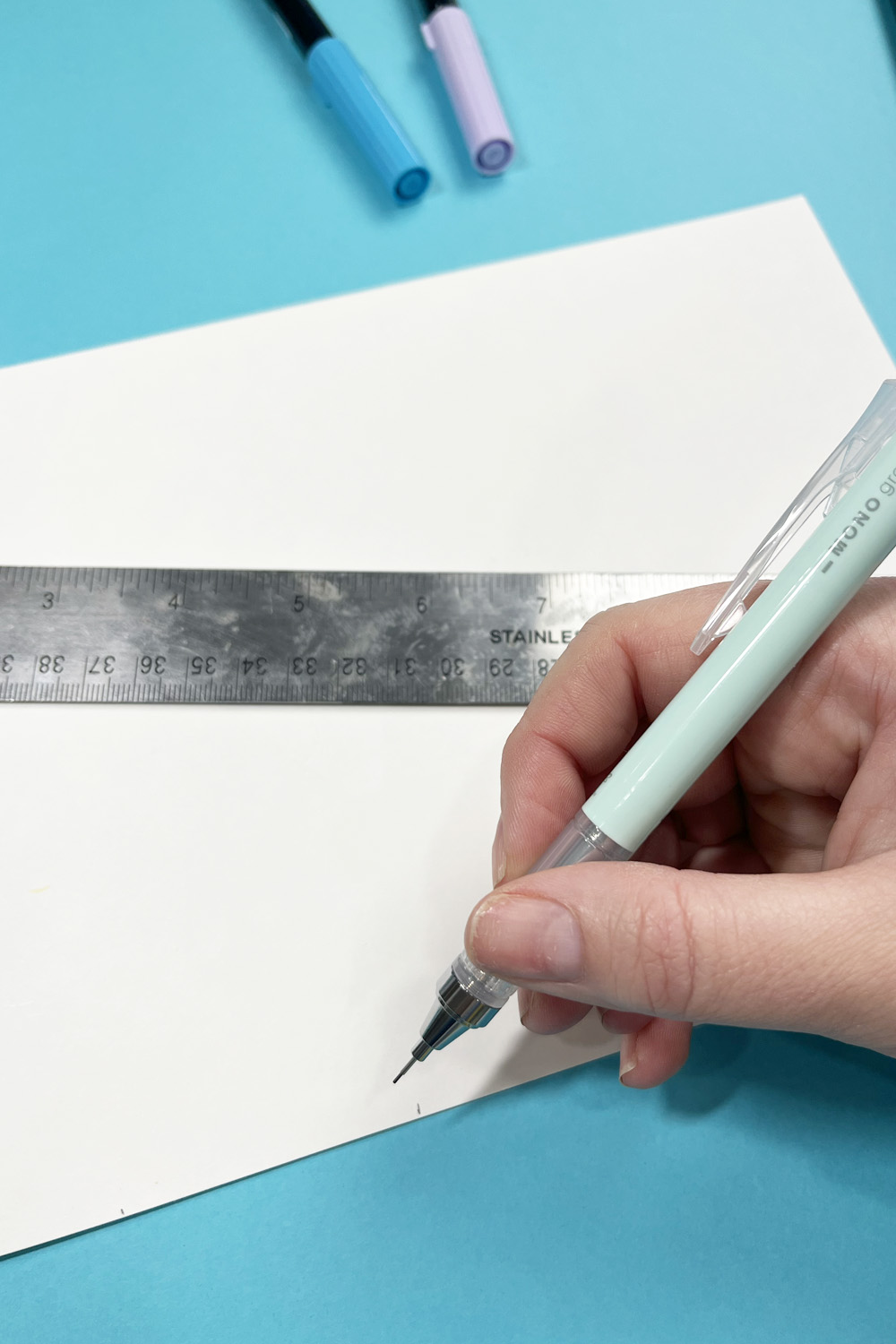 paper being marked with pencil and ruler