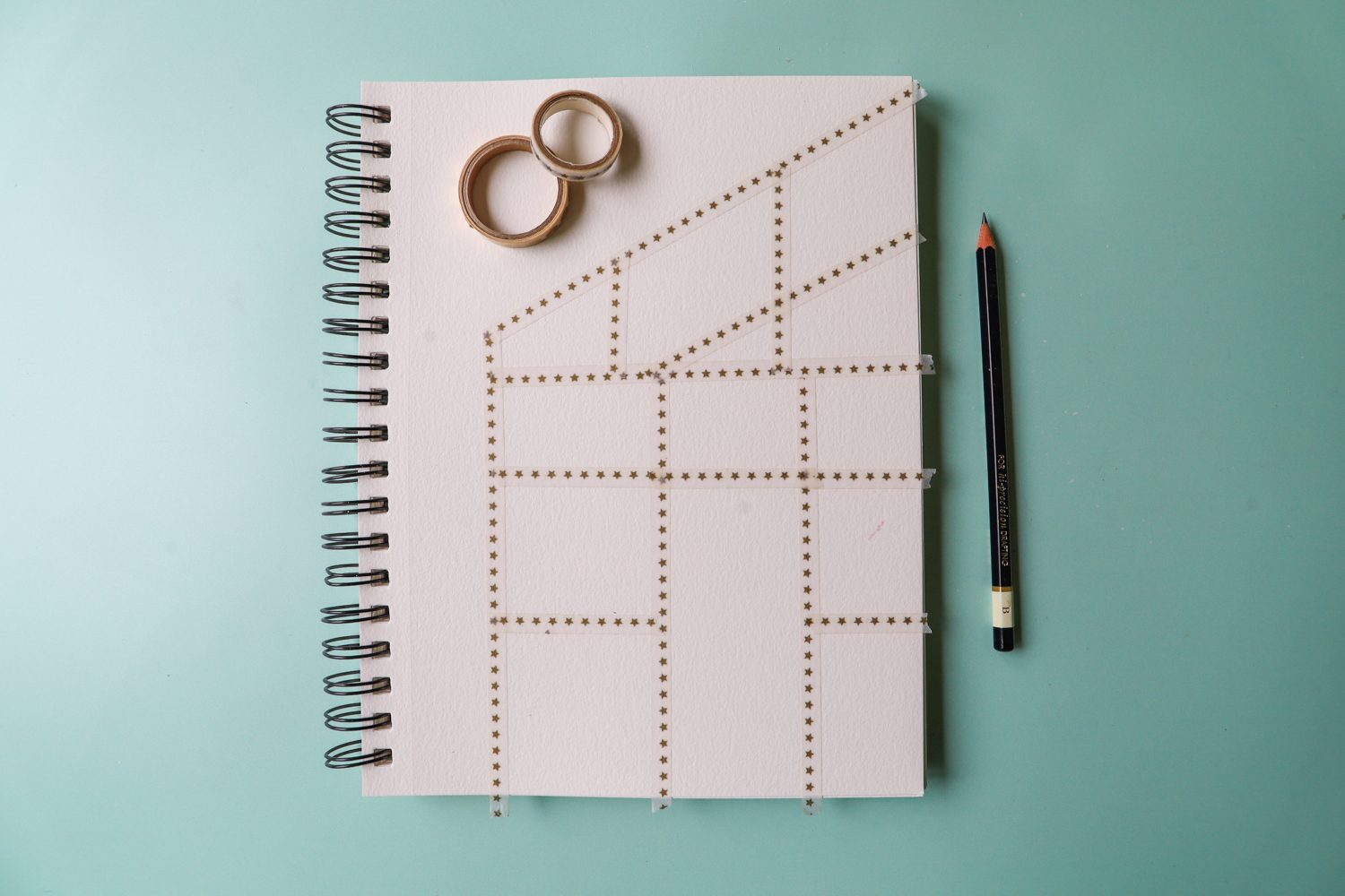 Use washi tape to create a greenhouse frame grid on a mixed media paper sketchbook
