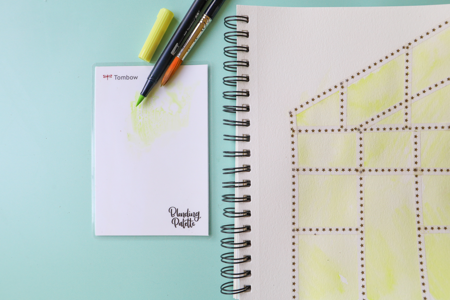 @tombowusa Dual Brush Pen 131 laying on the blending palette and coloring in the greenhouse drawing on a sketchbook