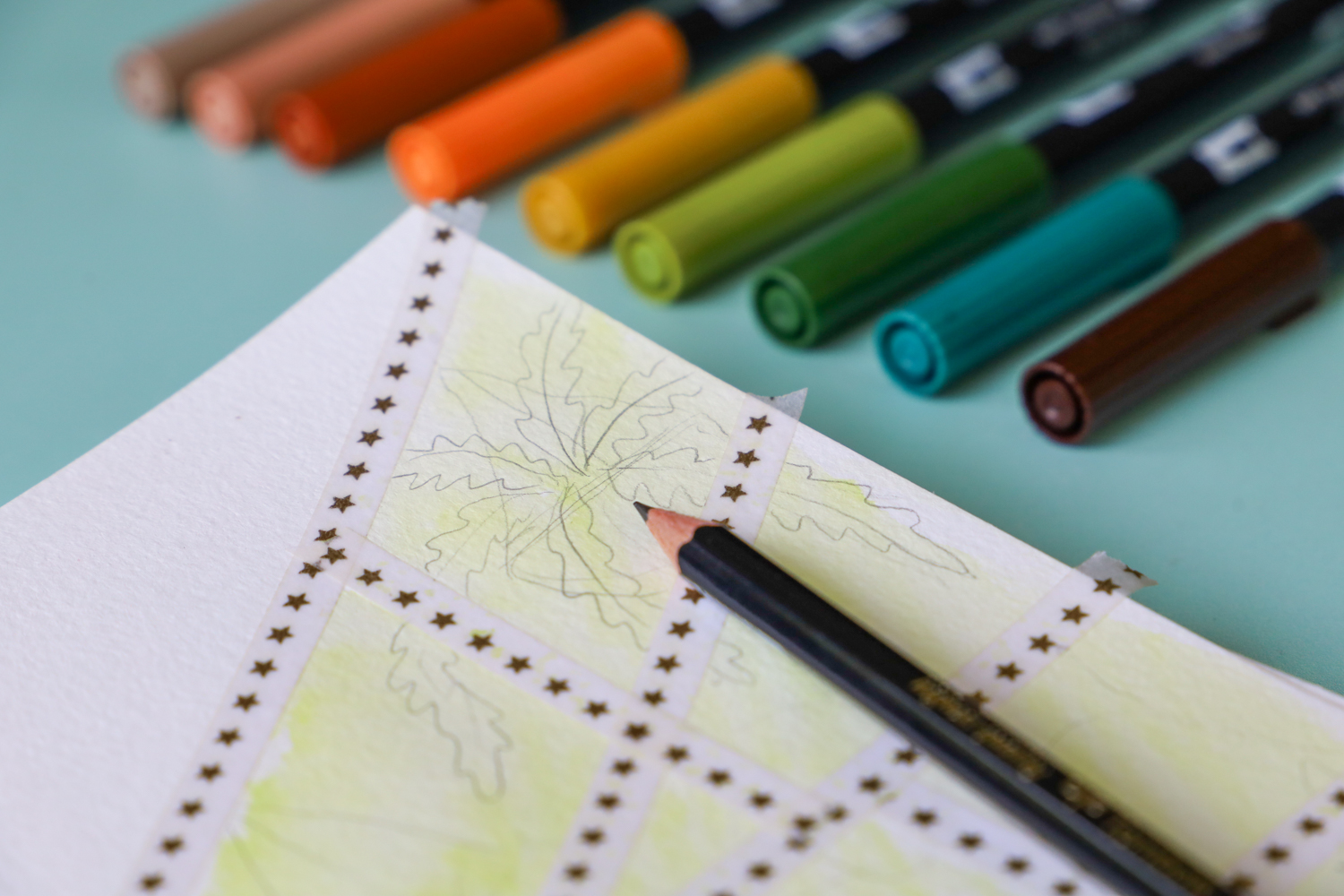 @tombowusa MONO Drawing Pencil laying on a sketch of a greenhouse and Dual Brush Pens laying to the side