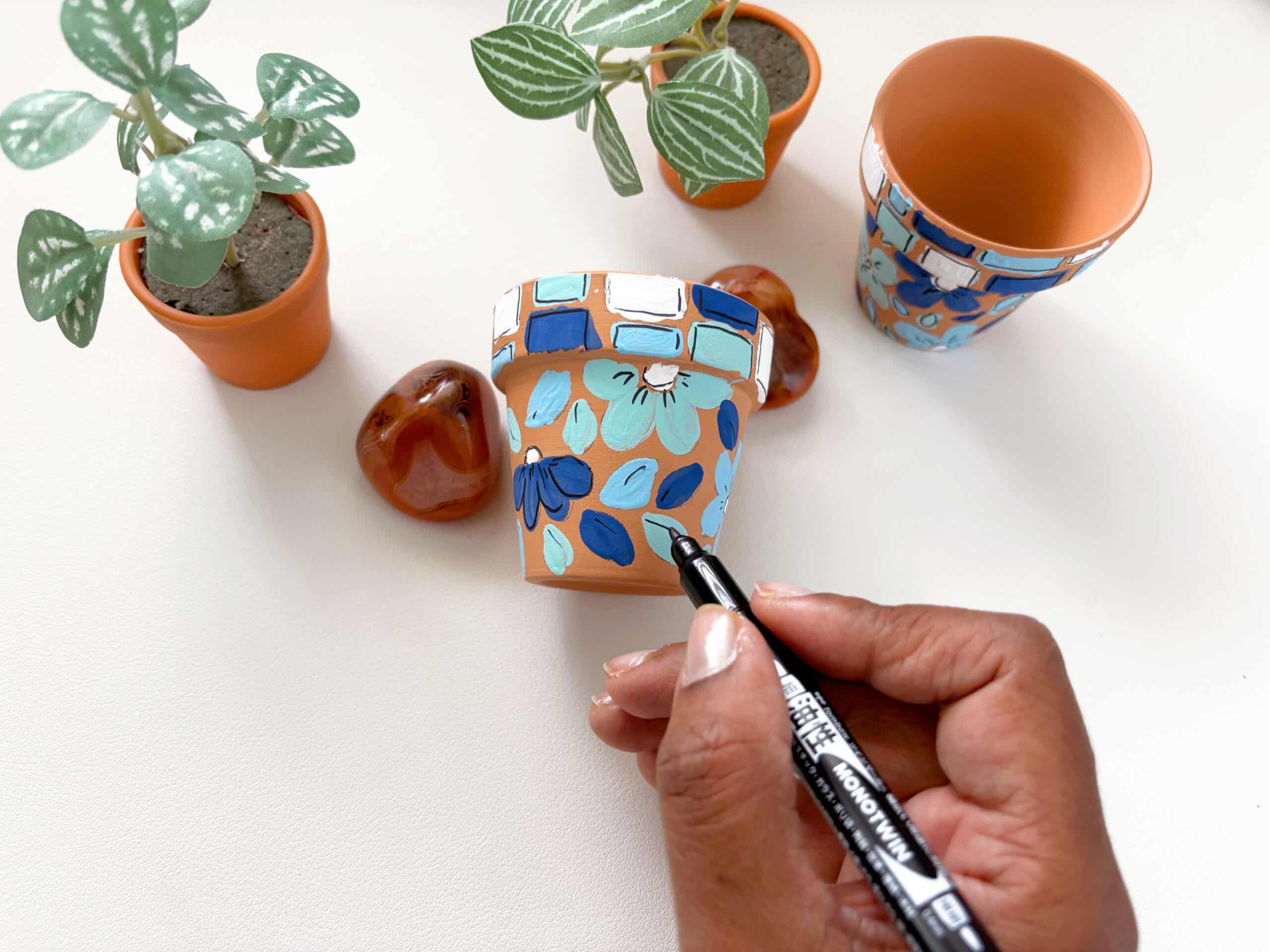 Learn how to use the MONO Twin Permanent Marker to add details to faux mosaic pots for your garden