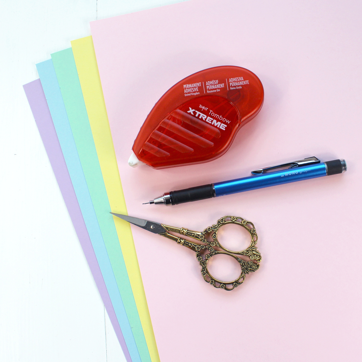 Colored pastel cardstock, scissors, mechanical pencil and Tombow Xtreme Adhesive roller