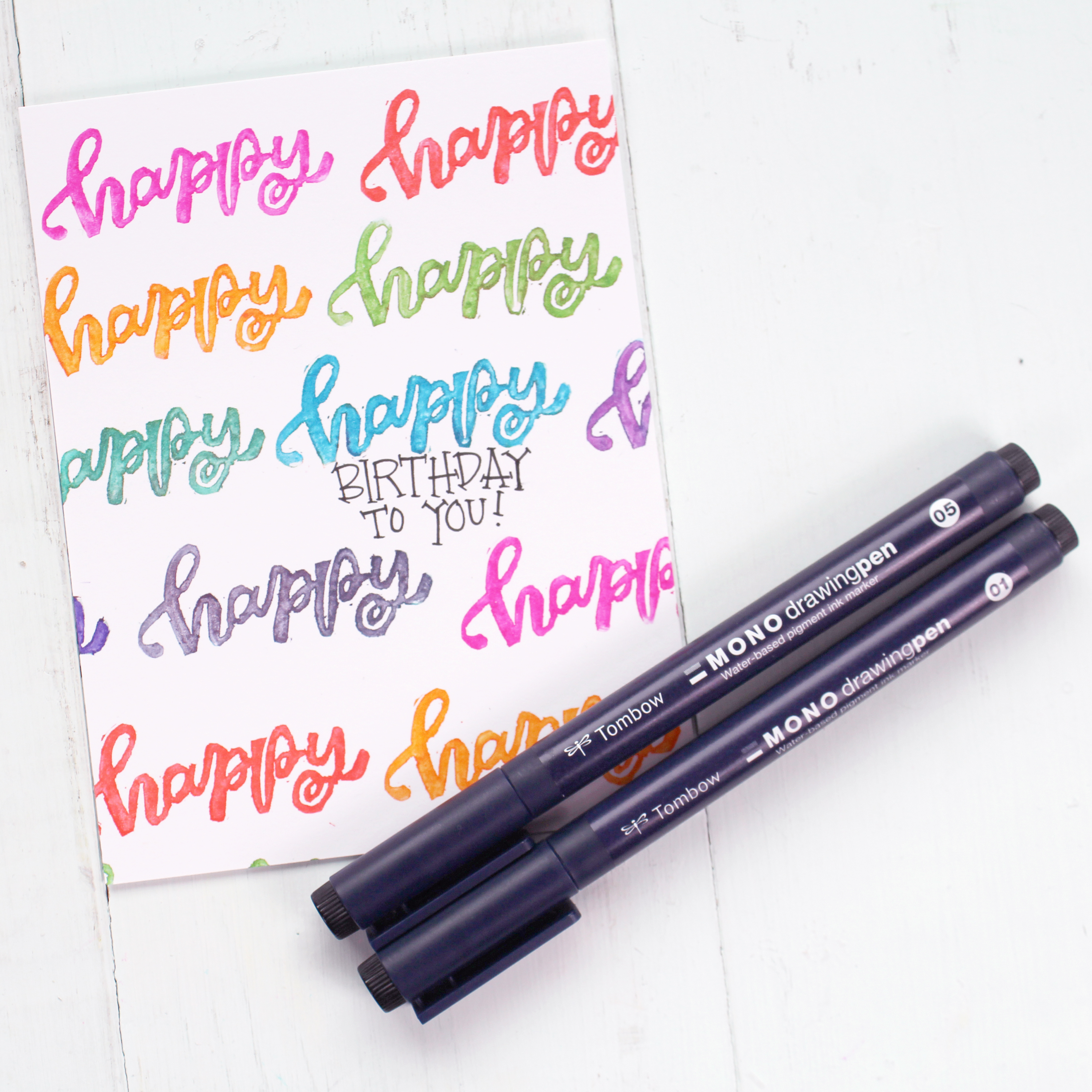 Add a sentiment with MONO Drawing Pens to a Happy Birthday card with a carved stamp made from a Tombow MONO Eraser.