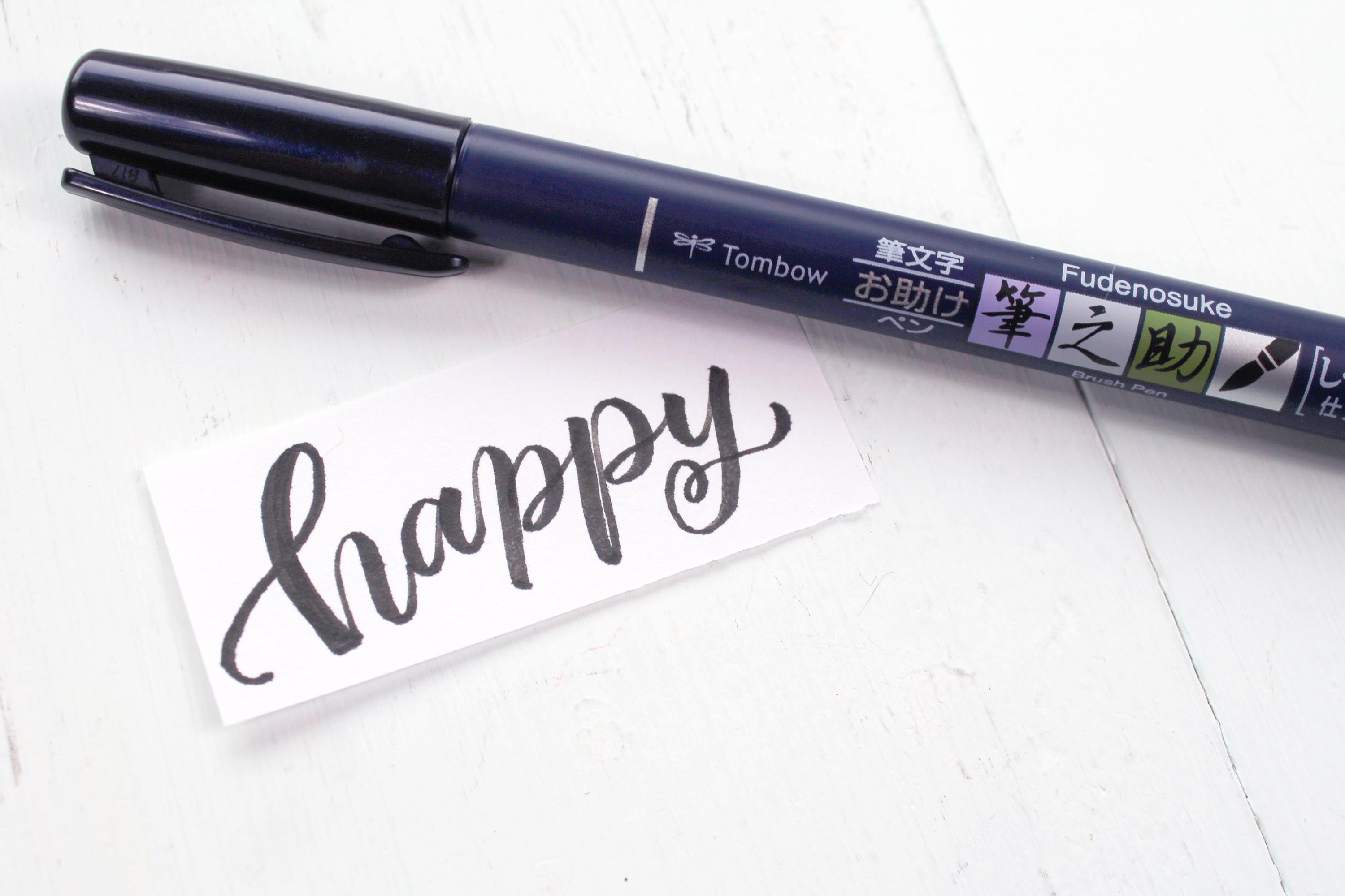 Write the word for a carved stamp with the Tombow Fudenosuke Pen on paper.